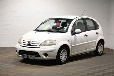 une petite voiture blanche garée dans un garage