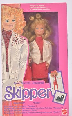 la boîte d'une poupée Barbie aux cheveux blonds et vêtue d'une veste blanche