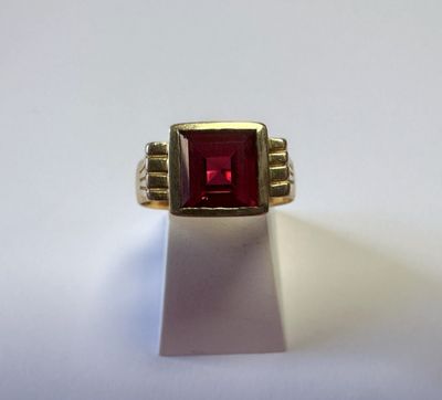 Gros plan sur une bague contenant une pierre rouge