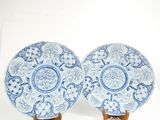 pair of blue and white plates on wooden stands