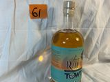 une bouteille de rhum posée devant un drap blanc