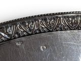 a silver plate with a decorative design on it