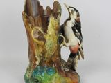 une figurine représentant un oiseau perché sur une souche d'arbre