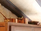 pots and pans on top of a shelf in a kitchen