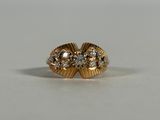a close up of a gold ring with diamonds on a white surface