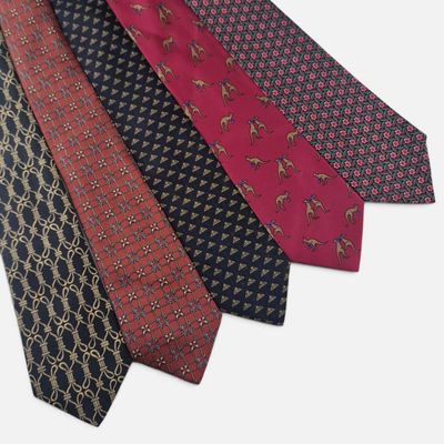 four different colored ties are lined up on a white surface