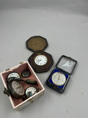une boîte contenant une montre-bracelet et une montre de poche, posée sur une table