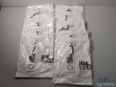 two bags of white t - shirts sitting on top of a table