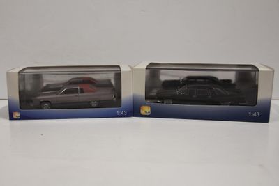 deux boîtes contenant chacune une voiture noire et une voiture rouge