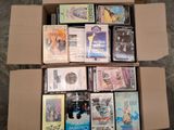 un grand nombre de DVD dans une boîte en carton posée sur le sol