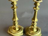 pair of antique brass candlesticks on a grey background