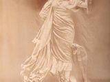 une statue de femme tenant un oiseau dans sa main
