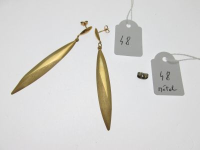 deux paires de boucles d'oreilles en or, avec leurs étiquettes, posées sur un fond blanc