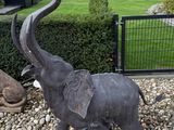 a statue of an elephant and a statue of an elephant in a garden