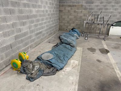 un sac de couchage posé à même le sol d'un parking à étages