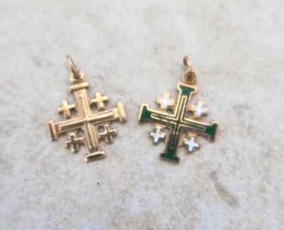 deux croix dorées et vertes sont posées sur une table
