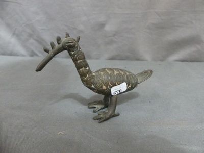 a small bronze bird with a tag on it ' s neck