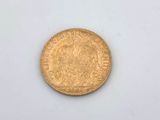 a close up of a gold coin on a white surface