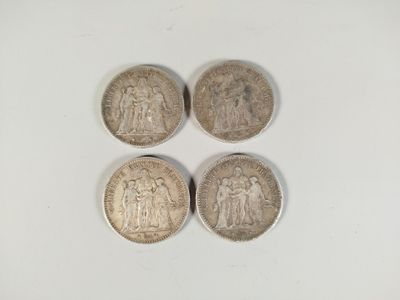 quatre types différents de pièces d'argent sur une surface blanche