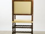 an old wooden chair with a beige upholstered seat