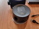 a table with a laptop, headphones, and a speaker on it