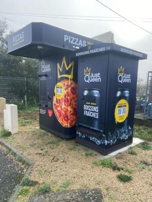 deux cartons sur lesquels sont dessinées des pizzas, posés sur le bord de la route