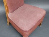 an old chair with a pink upholstered seat and wooden legs