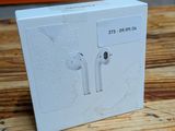 a white box on a wooden table with an apple airpods on it
