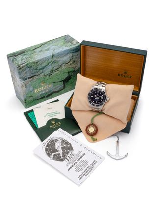 une photo d'une montre Rolex dans son coffret, avec son contenu