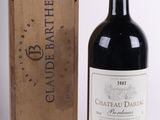 une bouteille de vin rouge devant une caisse en bois