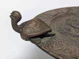 a bronze plate with a bird on top of it