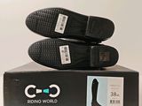 two pairs of black shoes sitting on top of a box