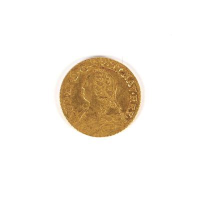 gros plan d'une pièce d'or sur une surface blanche