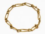 gros plan d'un bracelet en chaîne en or sur fond blanc
