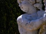 a statue of a boy holding a flower in his hand