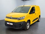 La camionnette jaune est garée dans une pièce blanche au sol noir