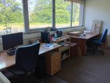 un bureau avec deux ordinateurs et une chaise devant une fenêtre