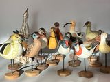 a lot of birds that are standing on wooden stands