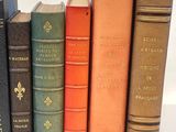 several books are lined up in a row on a white surface