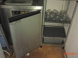 an image of a small kitchen with a refrigerator and shelves
