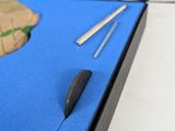 a blue box with a pen and a pair of scissors in it