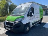 a green and white van parked in front of a building