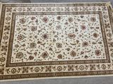 un tapis blanc bordé de marron posé au sol