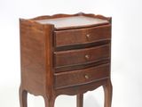 a small wooden table with three drawers on it