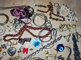 many different types of necklaces and bracelets laid out on a table