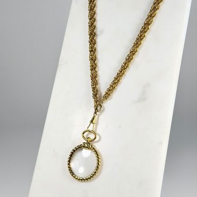 un collier composé d'une chaîne en or et d'un pendentif en pierre blanche