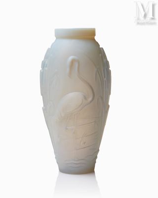 un vase blanc orné d'un oiseau, posé sur une surface blanche