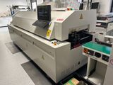 une image représentant une machine dans une usine, sur laquelle est posé un ordinateur portable
