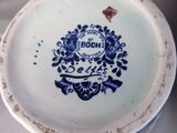 a close up of a blue and white plate with a bird on it