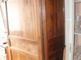 a tall wooden cabinet with a mirror on top of it